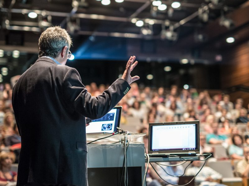 Speaker presenting at a corporate business conference