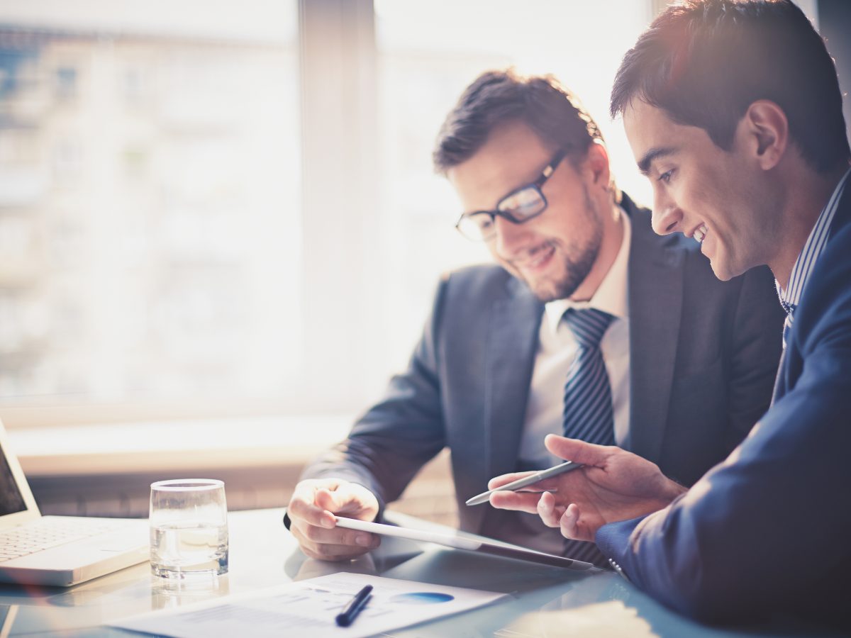 Image,Of,Two,Young,Businessmen,Using,Touchpad,At,Meeting