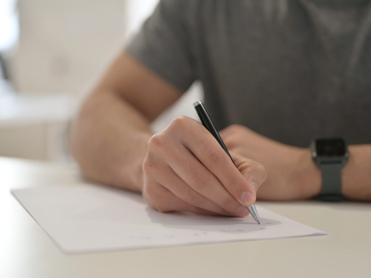 Hands,Of,Young,Man,Writing,On,Paper,,Close,Up