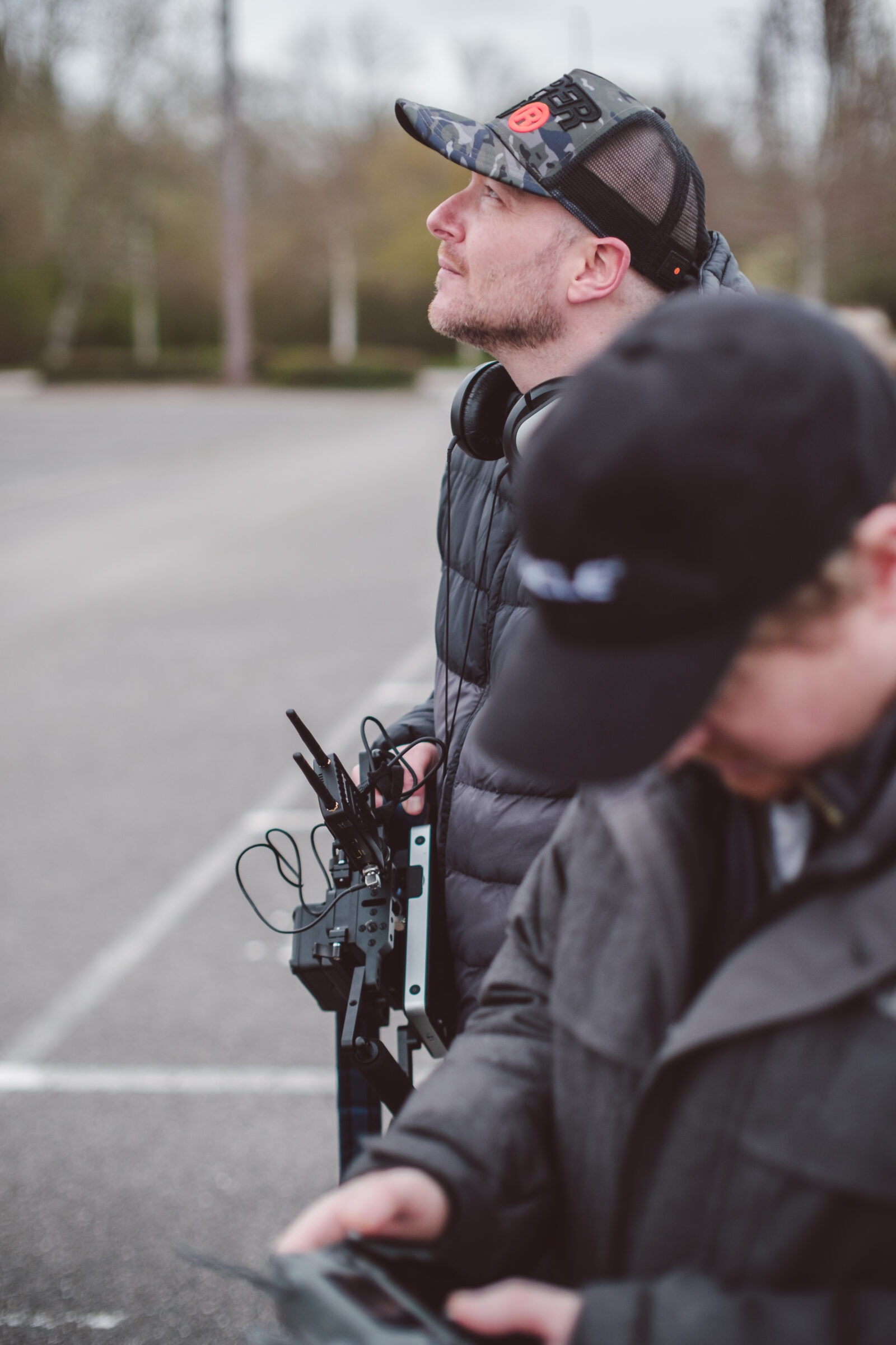 Director and crew watching drone flight on outdoor video production shoot - Zealous Media