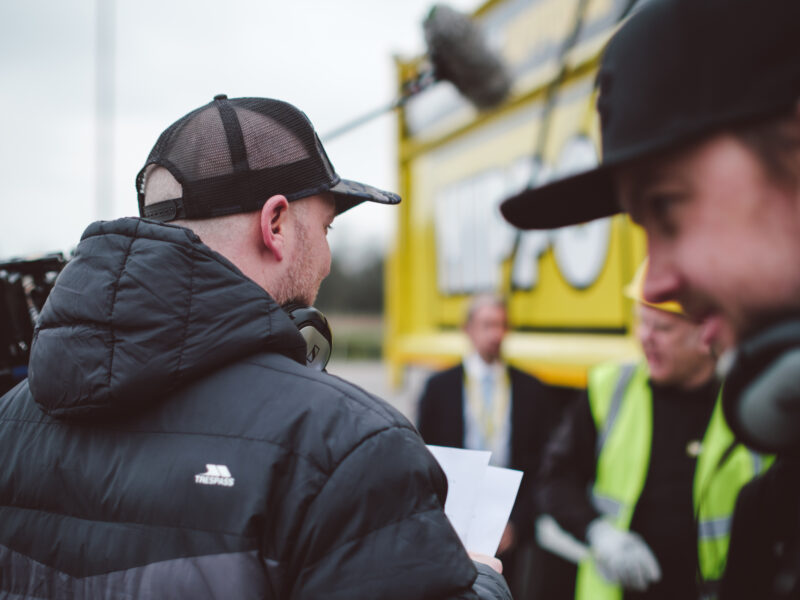 Director with script and boom op on corporate video location shoot - Zealous Media