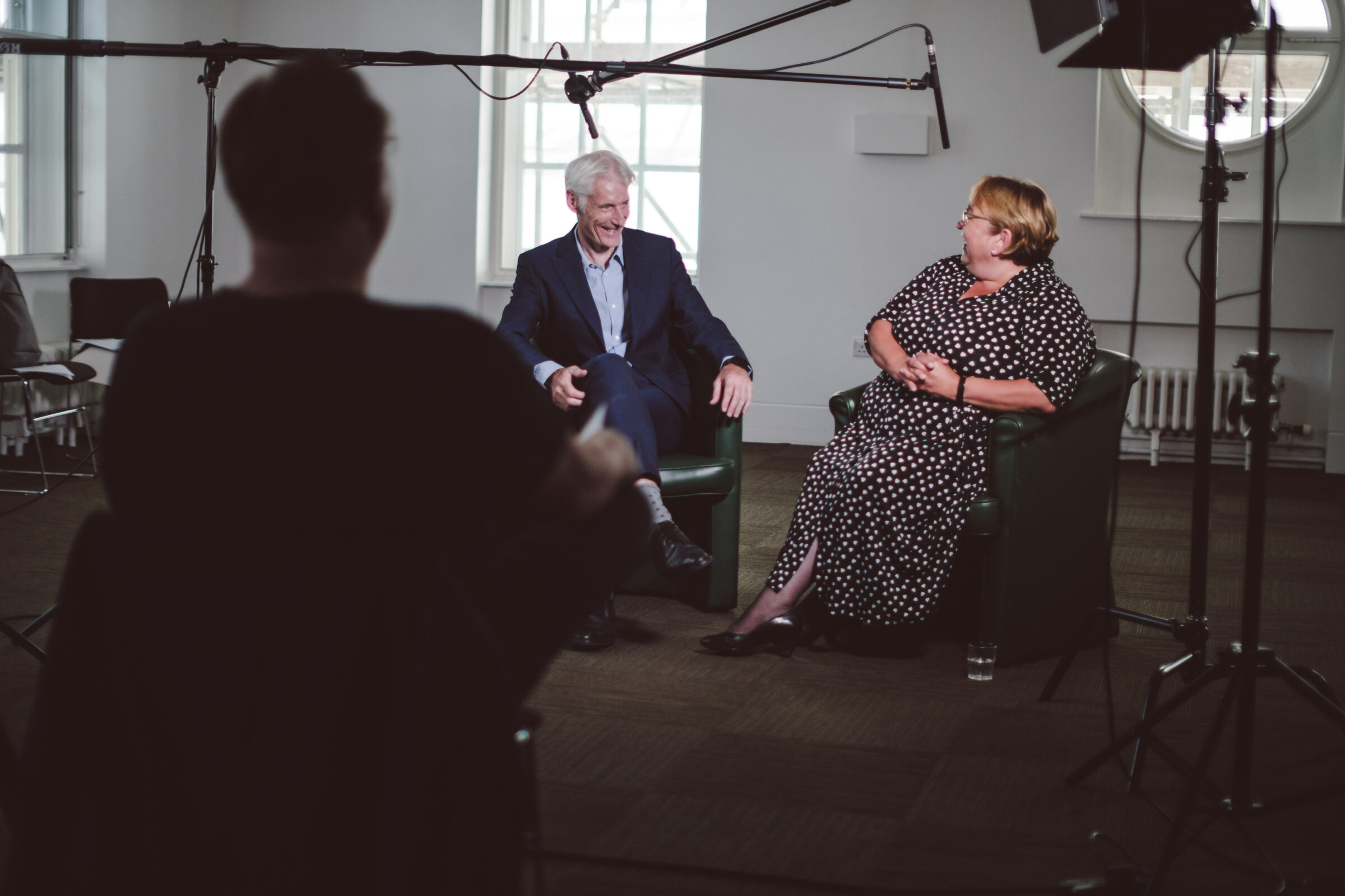Documentary interview behind the scenes setup with director in foreground - Zealous Media