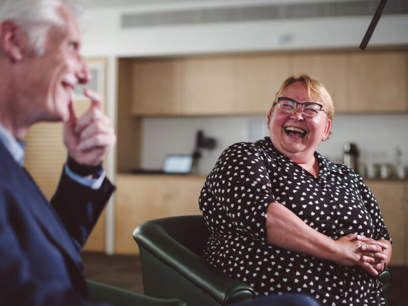 Two interview subjects laughing during documentary style corporate testimonial shoot - Zealous Media