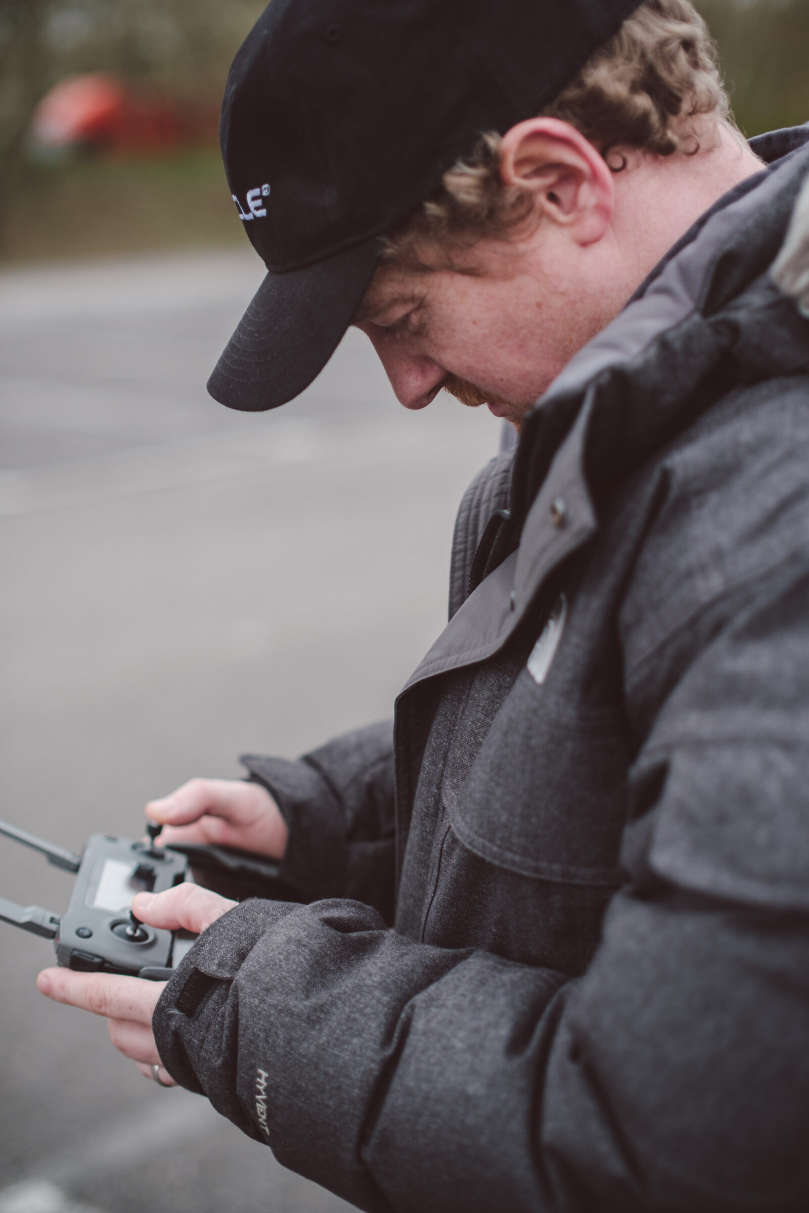 Drone pilot with DJI controller closeup during outdoor corporate video shoot - Zealous Media