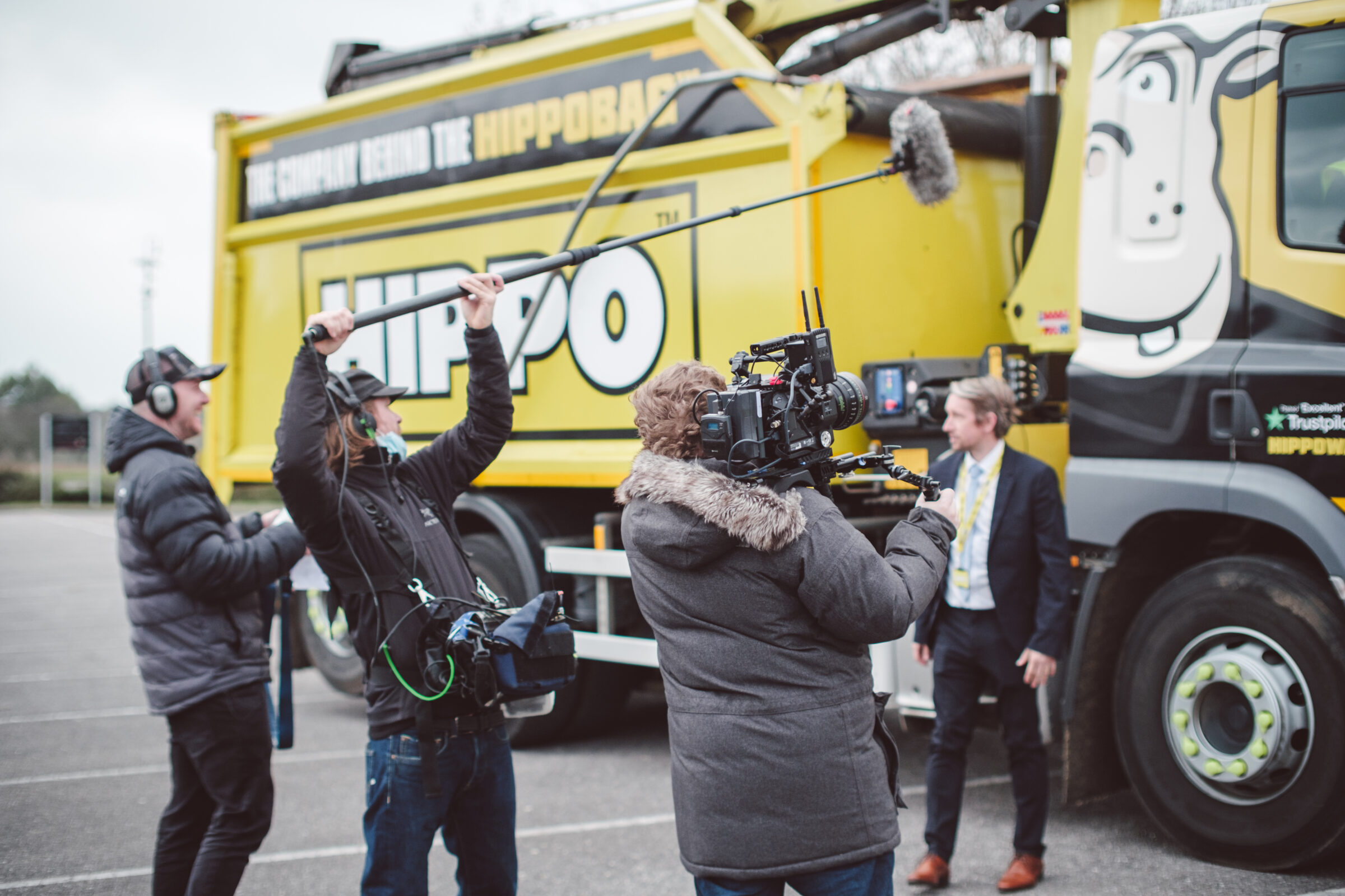 Film crew behind the scenes wide shot on outdoor corporate video shoot - Zealous Media