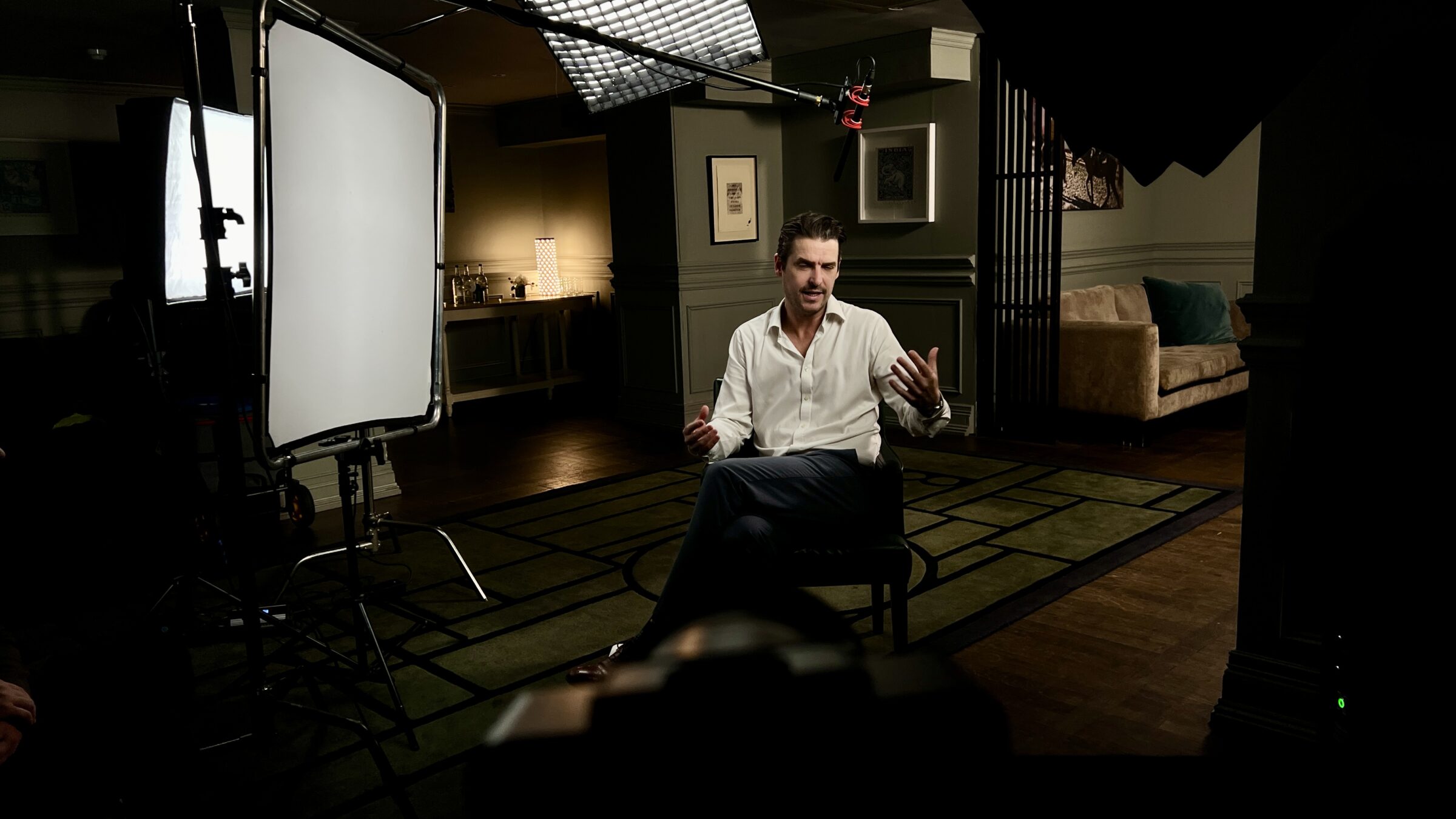 Interview setup with softbox lighting and boom mic in elegant room with subject - Zealous Media