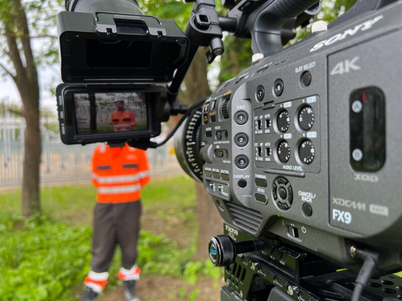 Sony FX9 professional video camera filming on location with operator in high visibility jacket